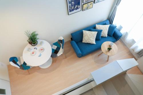 a living room with a blue couch and a table at つるのや鶴見105 in Yokohama