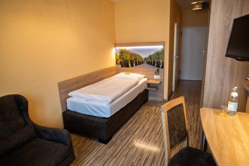 a bedroom with a bed and a couch and a table at City Hotel Hannover in Hannover