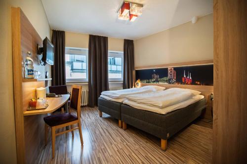 a hotel room with a bed and a table and a desk at City Hotel Hannover in Hannover