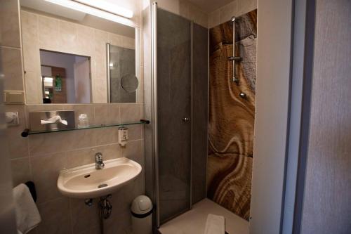 a bathroom with a sink and a shower at City Hotel Hannover in Hannover