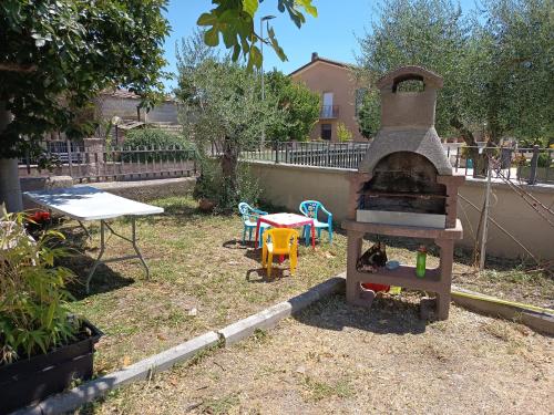 an outdoor oven in a yard with a table at Bully casa Vacanze in Spello