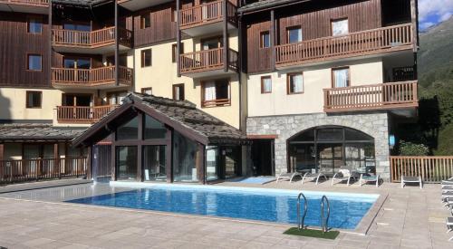 ein Hotel mit einem Swimmingpool vor einem Gebäude in der Unterkunft Résidence Les Alpages de Val Cenis in Lanslebourg-Mont-Cenis