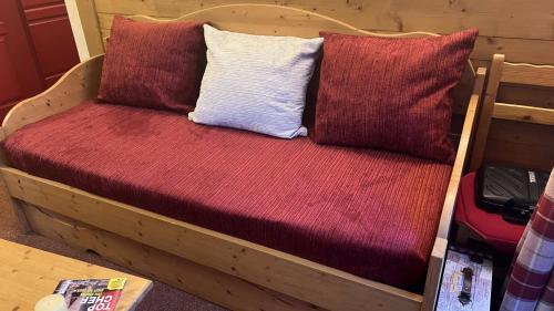 ein Holzbett mit drei Kissen darauf in der Unterkunft Résidence Les Alpages de Val Cenis in Lanslebourg-Mont-Cenis