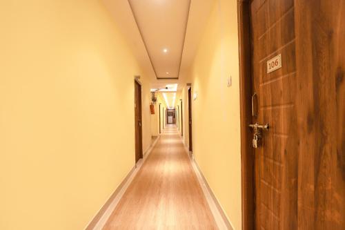 an empty corridor with a door and a long hallway at FabHotel Joy Residency in Chennai