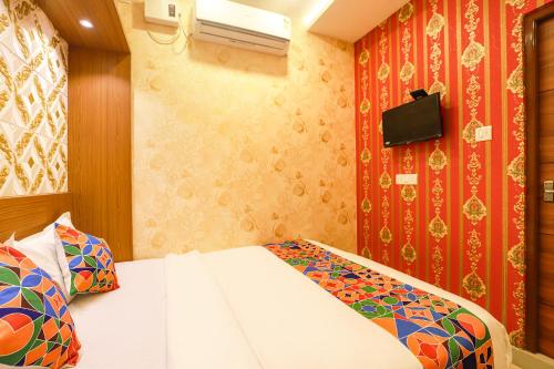 a small bedroom with a bed and a tv at FabHotel Joy Residency in Chennai