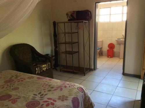 a room with a bed and a bathroom with a toilet at Tabonina Guesthouse in Livingstone