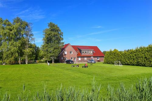 a large grassy field with a house in the background at Hof Lueck in Esens