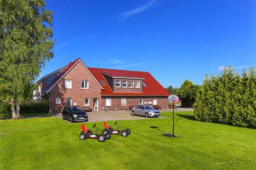 a house with three tricycles parked in the yard at Hof Lueck in Esens