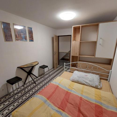 a bedroom with a bed and two stools in it at Chata na samotě u lesa in Lobendava