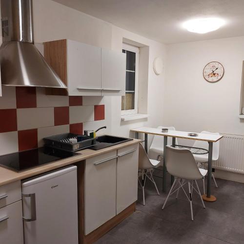 a kitchen with a sink and a table with chairs at Chata na samotě u lesa in Lobendava