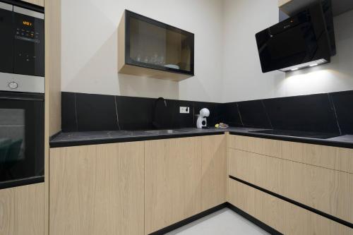 a kitchen with wooden cabinets and a flat screen tv at Apartamentos Constitución in Granada