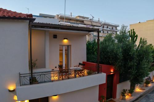a white building with a balcony with a table at City Cottage - Kalamata Villas in Kalamata