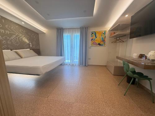 a bedroom with a bed and a desk and a window at MIRARI Design Rooms in Cala Gonone