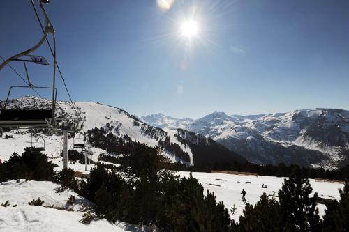 une remontée mécanique avec des personnes skier sur une montagne enneigée dans l'établissement Résidence Pierre & Vacances Les Trois Domaines, à Ax-les-Thermes