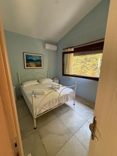 a bedroom with a white bed in a room with a window at Seaside Dream Kallithea in Kallithea Halkidikis