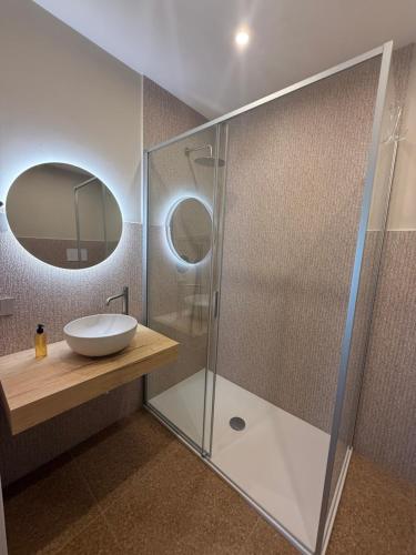 a bathroom with a sink and a glass shower at MIRARI Design Rooms in Cala Gonone
