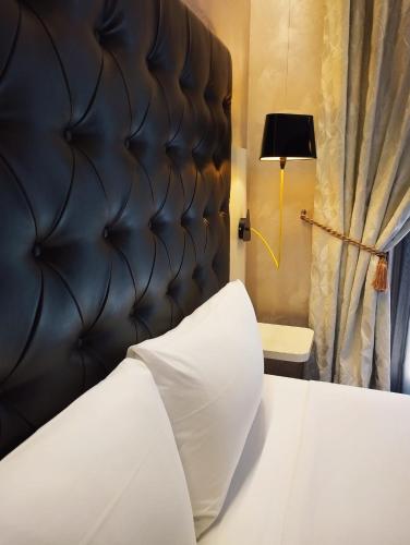 a bedroom with a white bed with a black headboard at Hotel Continental in Turin