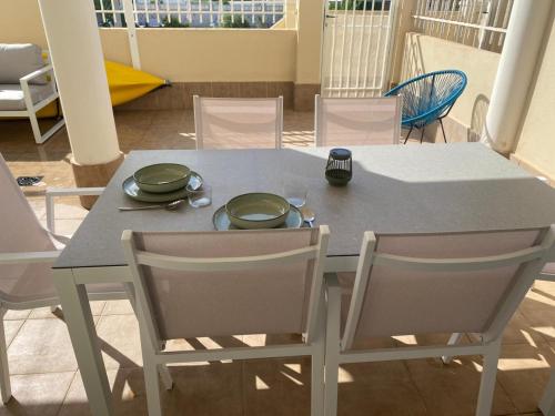 a table and chairs with plates and bowls on it at Relax time! in Casas Devesa