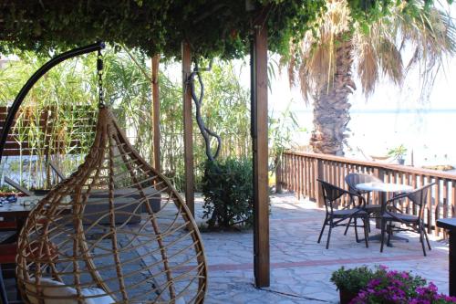 a hammock on a patio with a table and chairs at Seaside Dream Kallithea in Kallithea Halkidikis