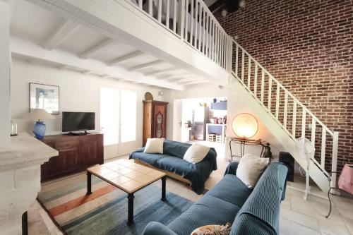 a living room with a blue couch and a staircase at Ecological house with solar electricity in Ajaccio