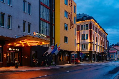 a city street with buildings and flags on the sidewalk at Original Sokos Hotel Puijonsarvi in Kuopio