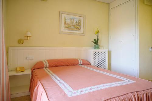a bedroom with a bed with a pink blanket at Hotel Paraíso in Lanjarón