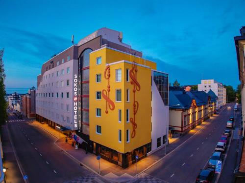 a yellow building on the side of a street at Original Sokos Hotel Puijonsarvi in Kuopio