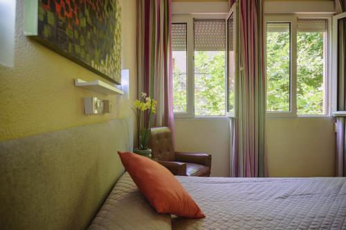 a bedroom with a bed with an orange pillow on it at Hotel Paraíso in Lanjarón