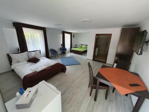 a bedroom with a bed and a desk and a table at Casa HAPPY in Sovata
