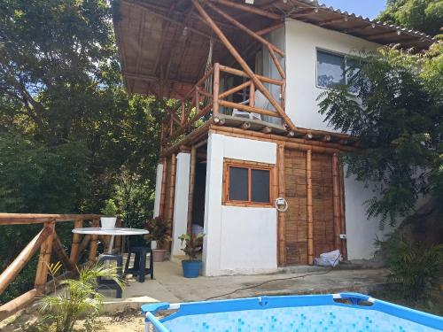 a house with a pool in front of it at El Eden Glamping cabañas Girardot in Girardot