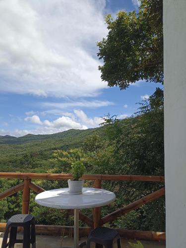 a white table and chairs on a balcony with a view at El Eden Glamping cabañas Girardot in Girardot