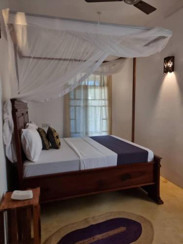 a bedroom with a bed with a canopy at Pahali in Bwejuu