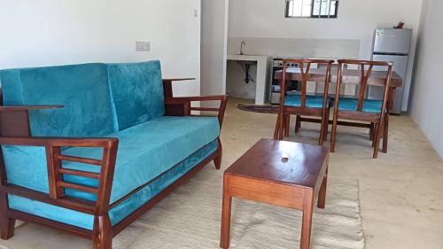 salon z kanapą, krzesłami i stołem w obiekcie Pahali w mieście Bwejuu