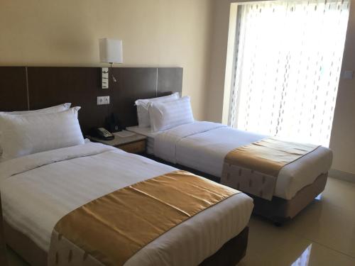 a hotel room with two beds and a window at Hotel Inter Tete in Vila-de-Santiago-Maior