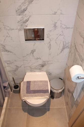 a small bathroom with a toilet and a trash can at Seaside Dream Kallithea in Kallithea Halkidikis