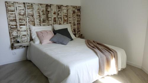 a bedroom with a white bed with two pillows at Valcros Paradis in La Londe-les-Maures