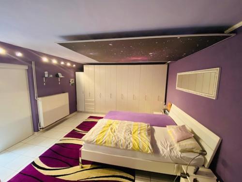 a bedroom with a bed with a purple wall at Wohlfühloase in Hofheim in Hofheim am Taunus