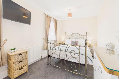 a bedroom with a bed and a tv on the wall at Host & Stay - Pier View in Amble