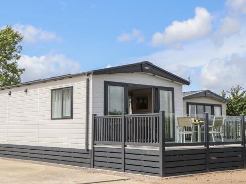 a small white house with a black fence at Maple Lodge in Newton Abbot