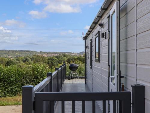 a balcony with a grill on the side of a house at Maple Lodge in Newton Abbot