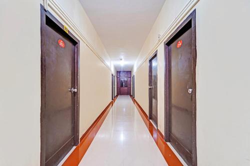 a corridor of a building with two doors at FabExpress Maruthi in Coimbatore