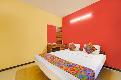a room with two beds with a red wall at FabExpress Maruthi in Coimbatore