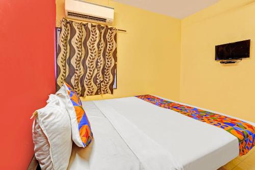a small bedroom with a bed and a window at FabExpress Maruthi in Coimbatore
