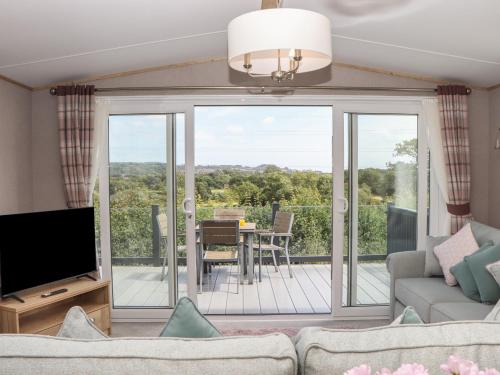 a living room with a couch and a television at Maple Lodge in Newton Abbot