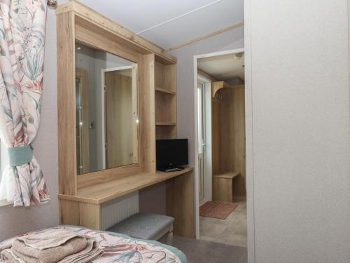 a bedroom with a mirror and a bed and a television at Maple Lodge in Newton Abbot