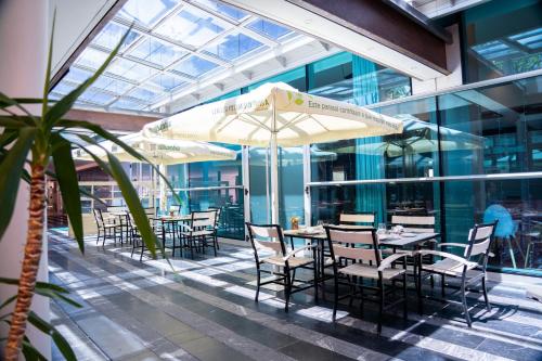 a restaurant with tables and chairs and an umbrella at Abba Playa Gijón in Gijón