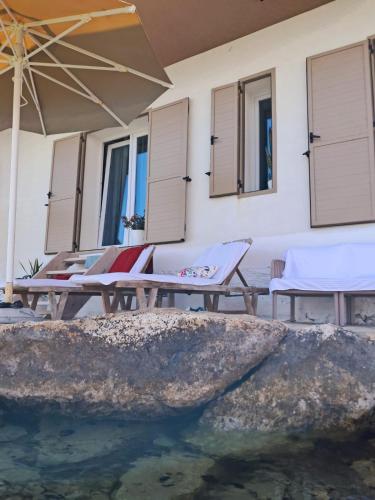 a patio with chairs and a pool of water at Artis Blue Relax in Himare