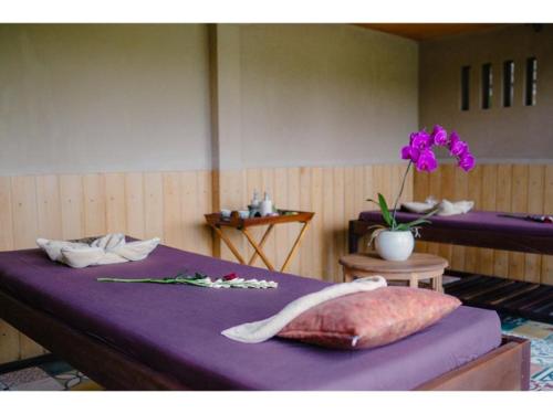 タバナンにあるAnggrek Sari Villaのベッド2台と花瓶が備わるお部屋