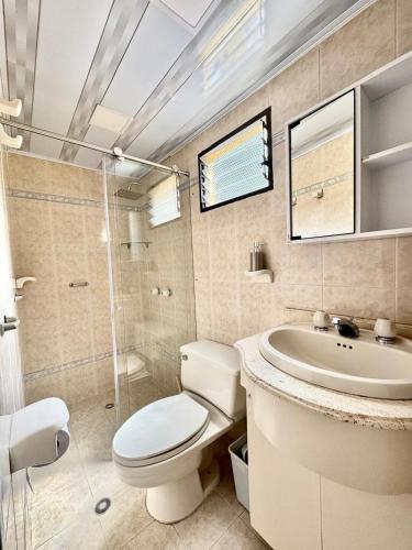 a white bathroom with a toilet and a sink at Casa hotel la 33 in Medellín
