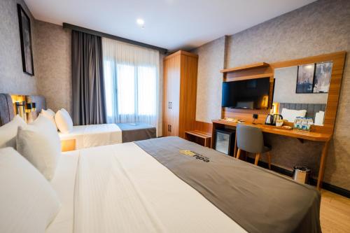 a hotel room with two beds and a desk at Educity Suite and Hotels Atasehir in Istanbul